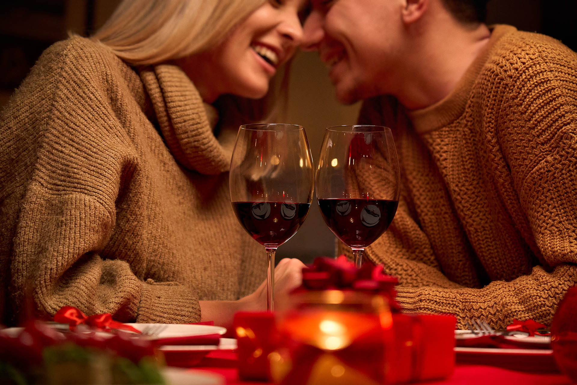 Happy couple celebrating Valentines day dining with red wine on Valentines day.